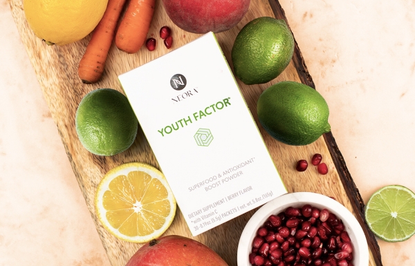 Lifestyle shot of Youth Factor® Superfood & Antioxidant Boost Powder sitting on a wood board with fruits and vegetables surrounding it.